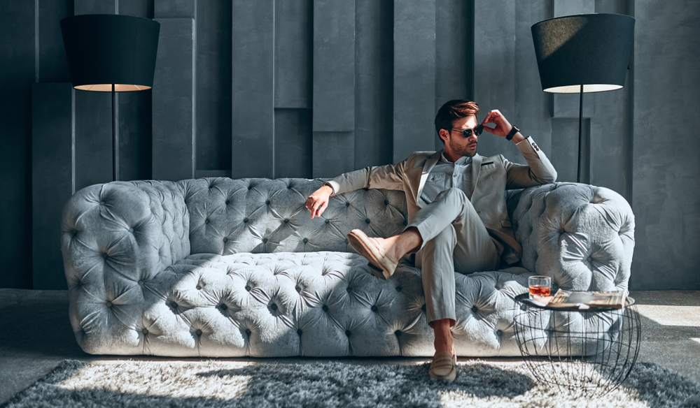 A stylish man sitting on a luxurious sofa