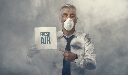 man in polluted air holding "fresh air" sign