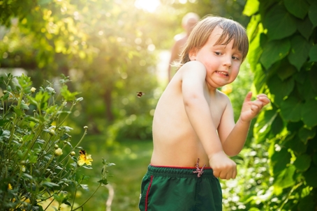 young boy moving away from a bee