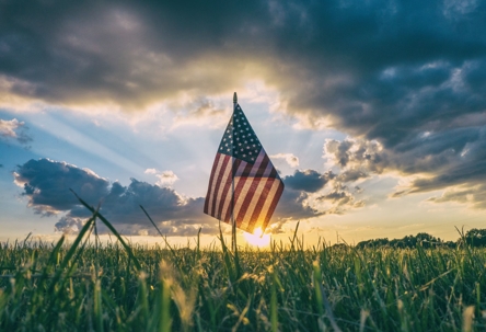 flag in a meadow at sunrise