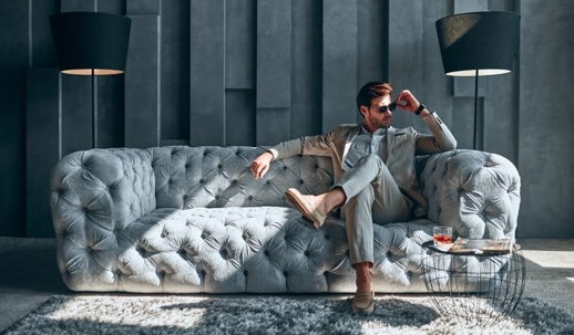 Stylish man sitting on luxurious sofa