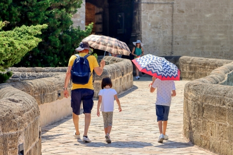 A father and 2 kids under umbrellas while walking