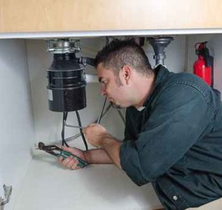 Technician fixing garbage disposal