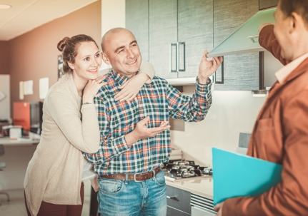 smiling mid-aged couple talking to a tech who has just performed a ClubOne routine maintenance