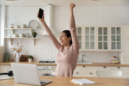 Excited woman in modern kitchen