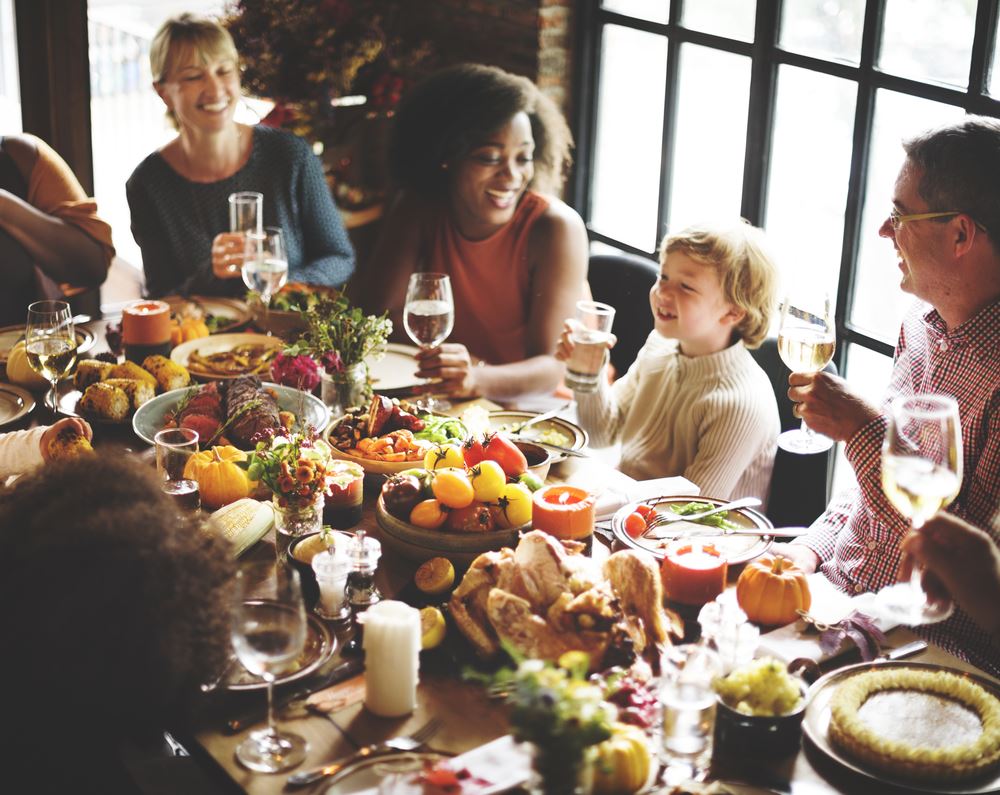 Family laughing around Thanksgiving table