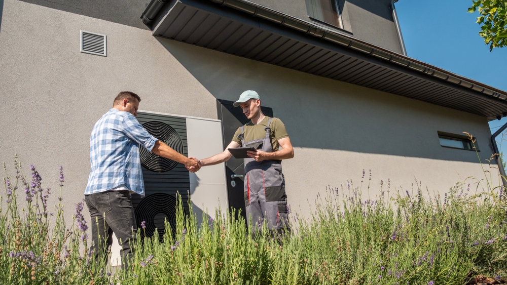 Homeowner and Contractor shaking hands in front of home