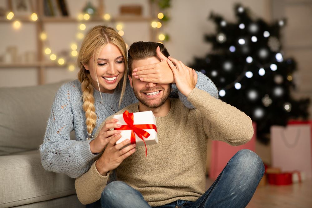 woman giving man a Christmas gift 