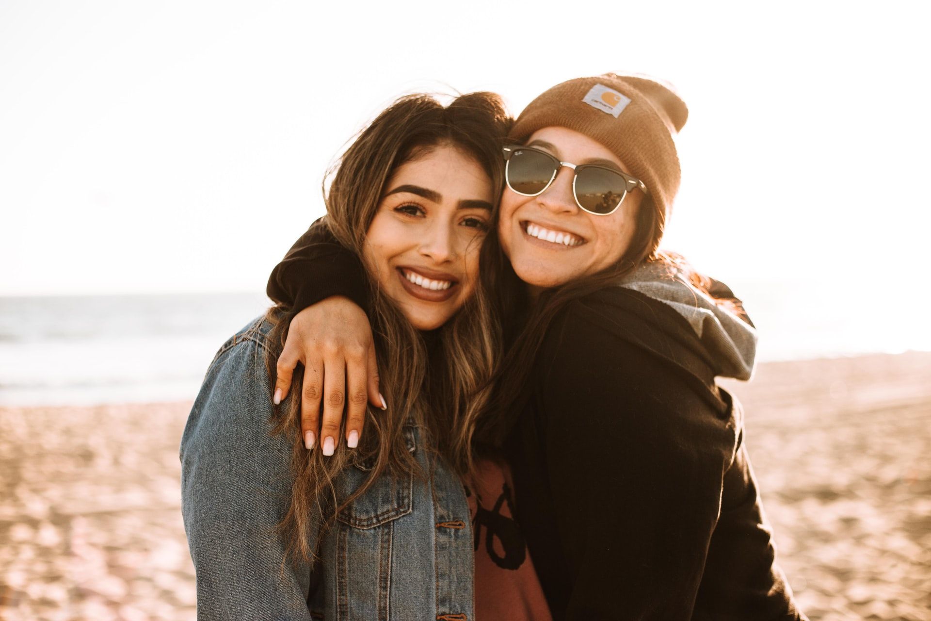 2 friends hugging on a beach