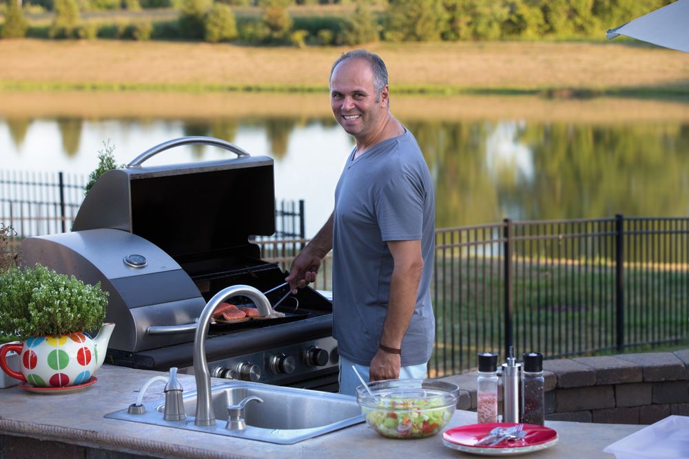 man cooking in outdoor kitchen