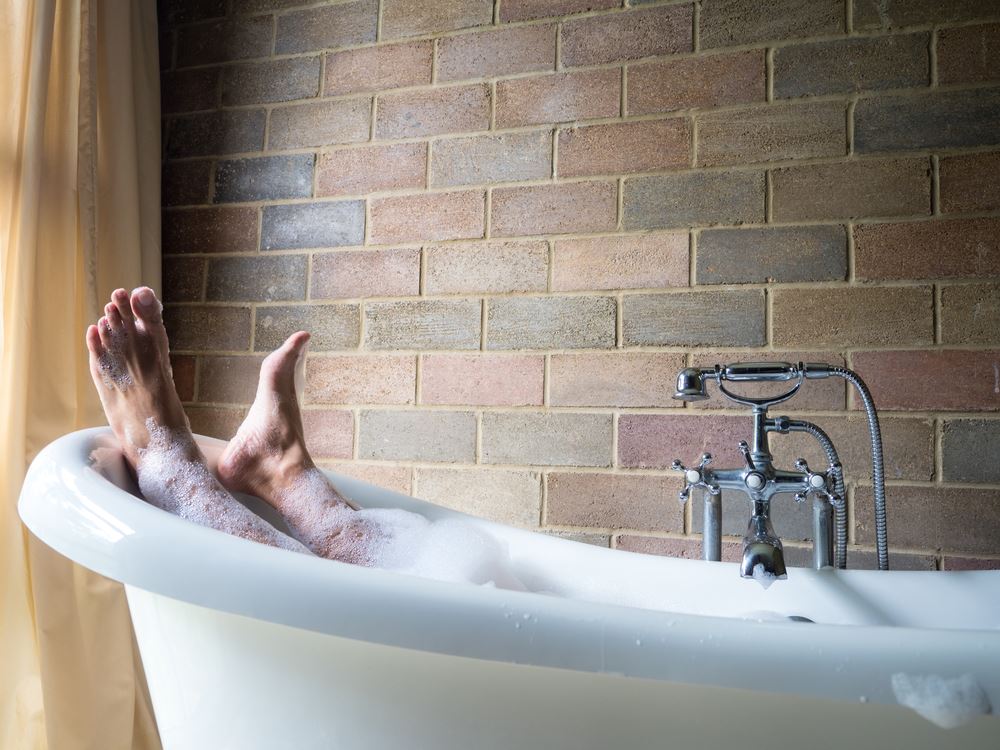 man's feet sticking out of hot bath