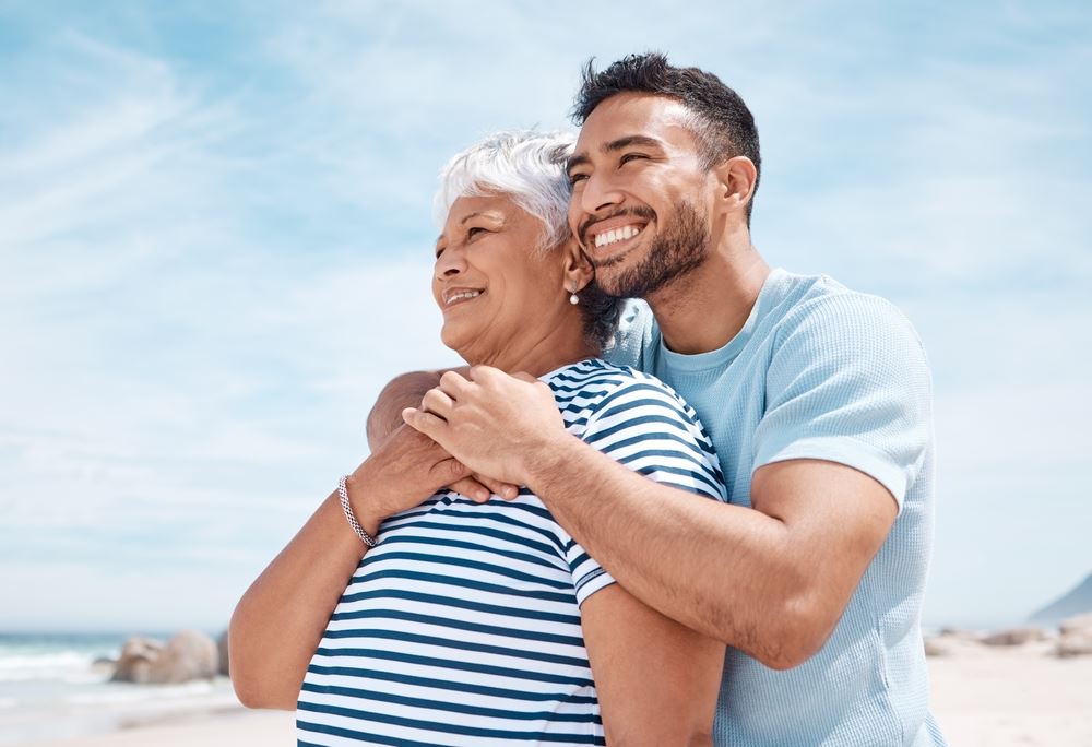 Man hugging mom a beach