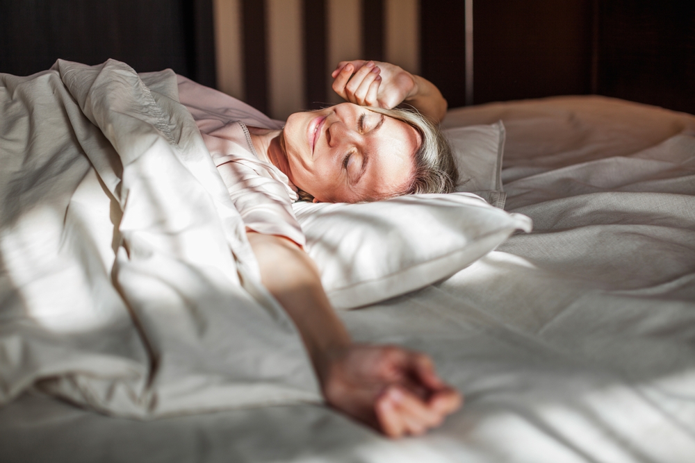 mature woman smiling as she wakes up after sleeping in a cool room